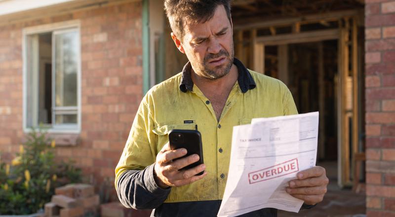 Australian tradie reviewing unpaid invoices